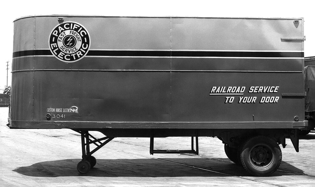 Historic photo showing an early PMT road trailer.
