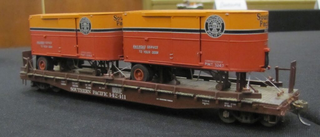 Model showing flat car with PMT trailers on it.